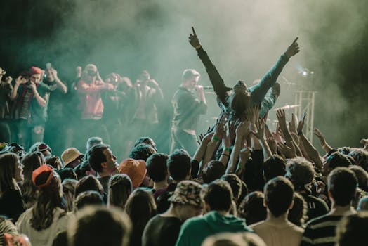 A vibrant concert scene with a crowd surfer and lively audience members enjoying a live performance.